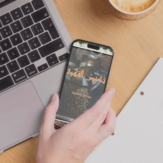 كتاب إلكتروني بعنوان تحميص القهوة | تعلم اسرار وكيفية تحميص القهوة للمبتدئين معروض على هاتف بجانب لابتوب وفنجان قهوة. مثالي لعشاق القهوة ومحبي التعلم الرقمي.